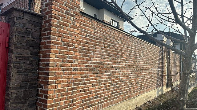 , kavkazskiy_ruchnik, oblitsovochnyy_kirpich, krasnyy_pyestryy, stena